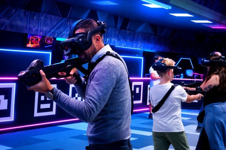 Joueur en casque VR visant avec une arme laser lors d'une session de tir immersif à Virtual Arena