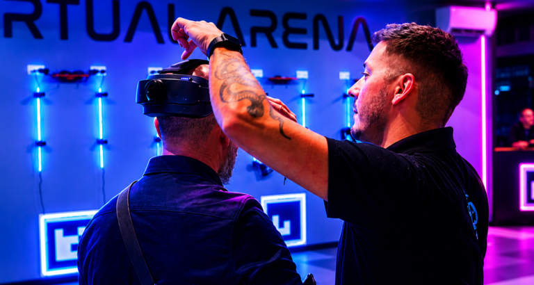 Un animateur Virtual Arena installe le casque de réalité virtuelle sur la tête d'un client
