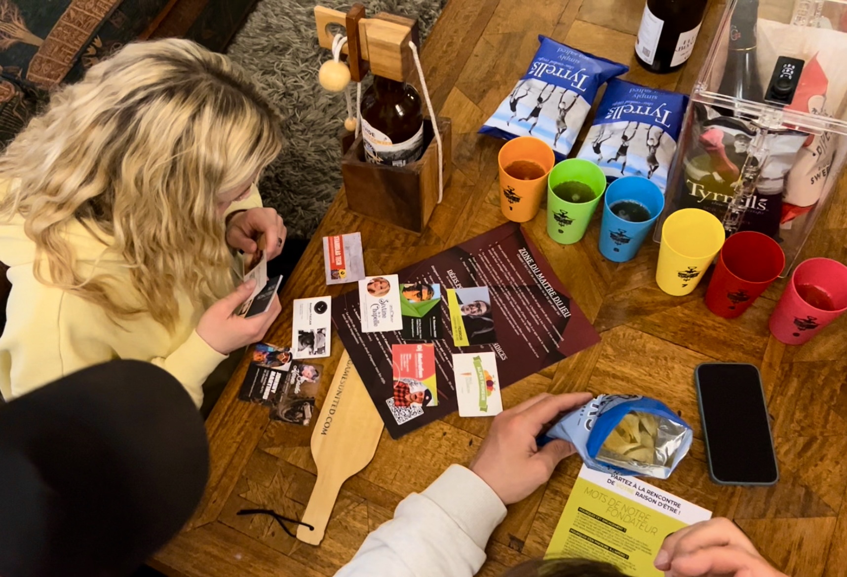 Table de jeu "Escape Games L'Apéro" avec cadenas, indices et gobelets colorés, vue du dessus