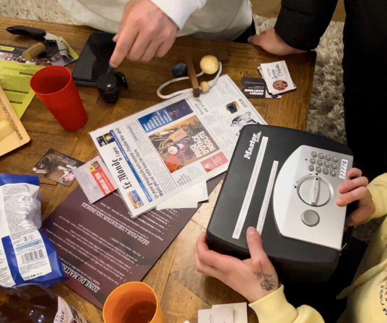 Coffre-fort à combinaison et indices du jeu "Escape Games L'Apéro" sur une table en bois