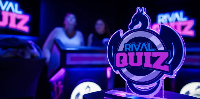 Trophée lumineux "Rival Quiz" en forme de dragon avec deux joueuses en arrière-plan