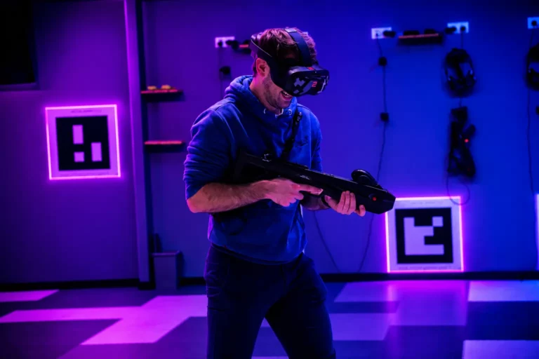 Joueur équipé d'un casque VR et d'un pistolet laser dans une salle d'arène aux néons violets