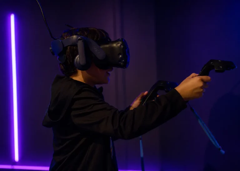 Adolescent équipé d'un casque VR et de manettes jouant à un escape game en réalité virtuelle